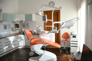 Modern dental treatment room with a dental chair and equipment, with no people present.